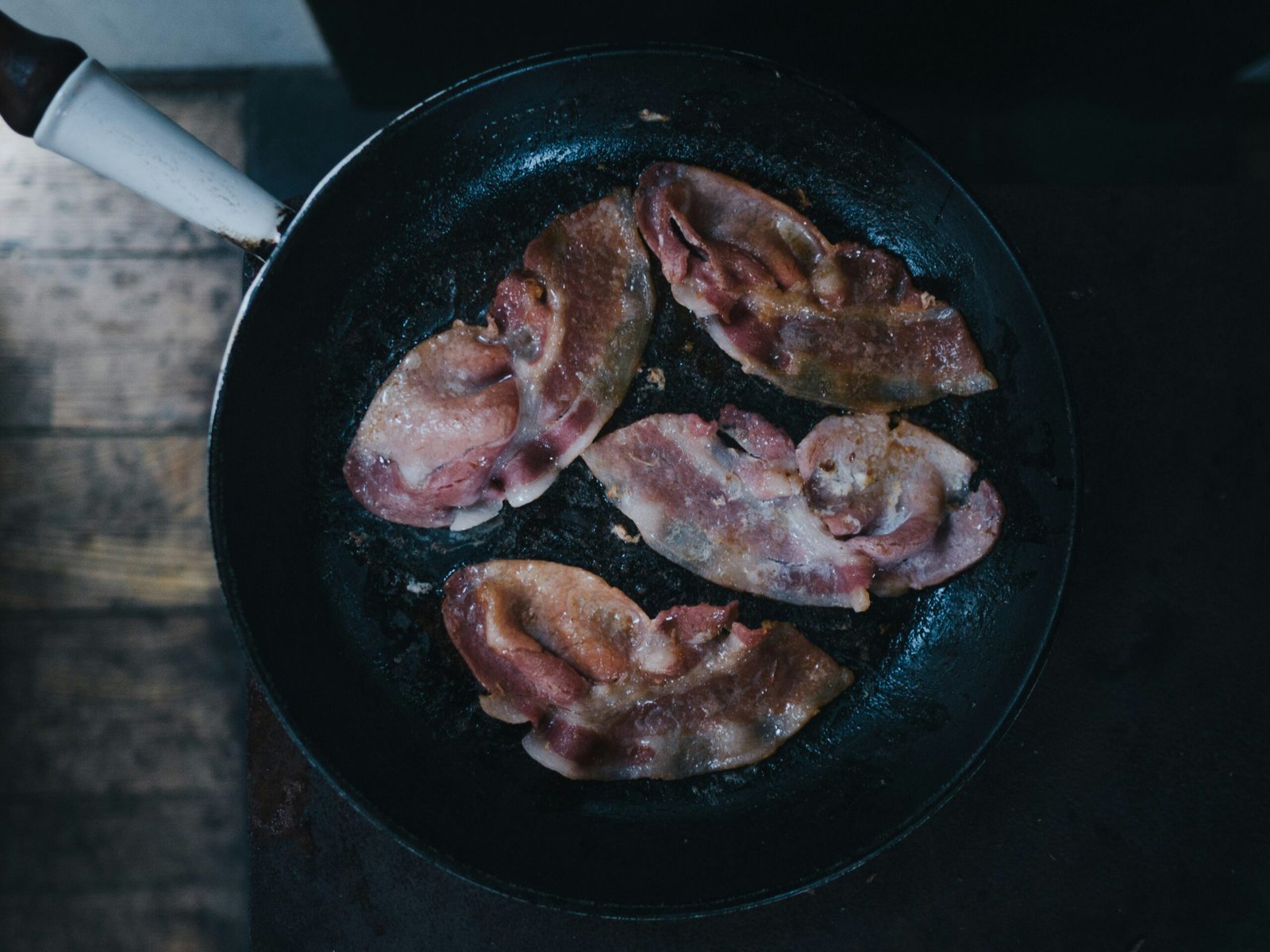 bacon on top of black cast-iron skillet